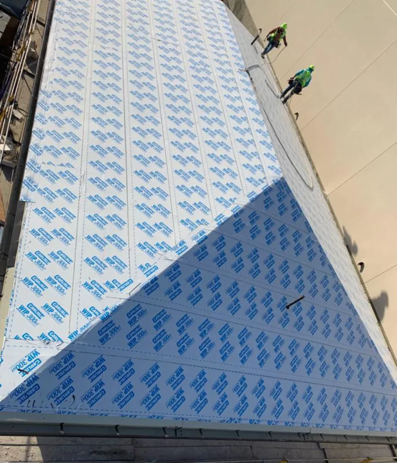 Professional roofers installing underlayment on a metal roof in Burlington